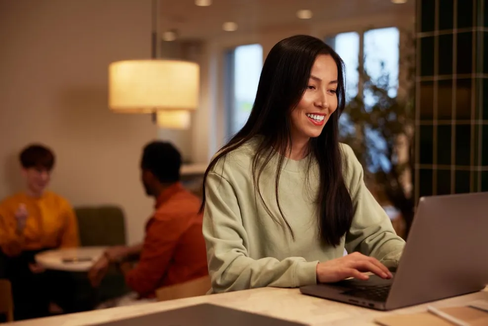 A young woman working on laptop smiling closeup