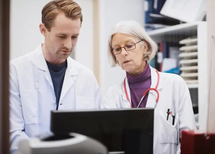 two medical professions looking at a computer screen