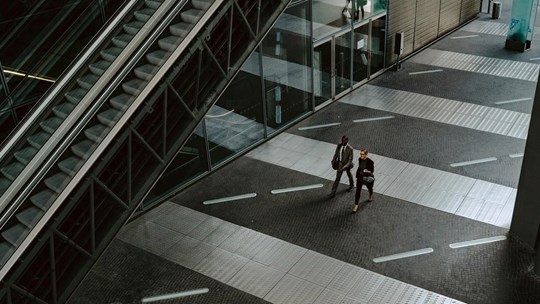 two people walking in financial district in urban environment modern architecture