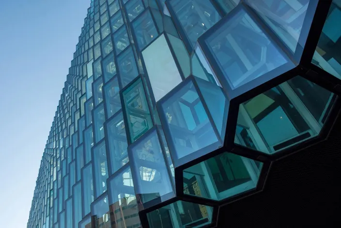 REYKJAVIK, ICELAND - MAY 24, 2019: The Harpa Concert Hall building features a distinctive colored glass facade inspired by the basalt landscape of Iceland