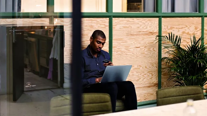 Young man using bank card paying online using laptop