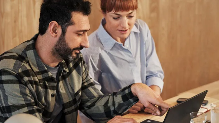 Young man and woman meeting and working on laptop discussing work